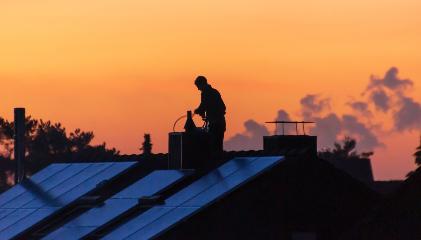 Schornsteinfeger auf dem Dach reinigt den Schornstein
